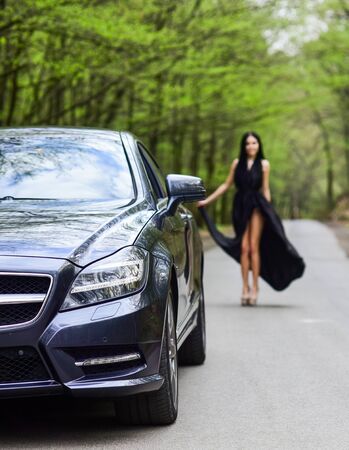 Symbol of richness. Travel by car. Auto service. Rich people lifestyle. Start journey. Luxury car. Auto and pretty sexy woman at road. Travel concept. Traveling and vacation. Transport conceptの写真素材
