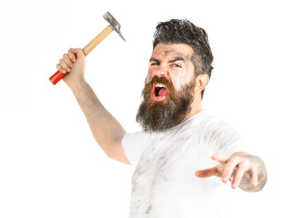 Mad repairman concept. Builder, plasterer, repairman, foreman attaks with hammerの写真素材