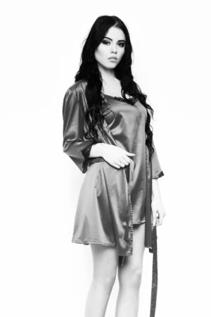 sexy girl posing in pink silk robe isolated on whiteの写真素材