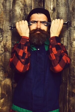 Bearded brutal caucasian mechanic holding metallic wrenchesの写真素材