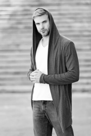 Male fashion influencer. Fashionable young model man. Carefree guy street style outfit with hood. Handsome man with hood standing urban background. Fashion trend. Comfortable clothes for daily wearの写真素材