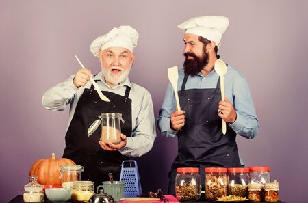Enjoying new great day. Healthy food cooking. Chef men cooking. cheerful men prepare food. mature senior bearded men in kitchen. Halloween pumpkin recipe. cereals and seasoning. professional cookの写真素材