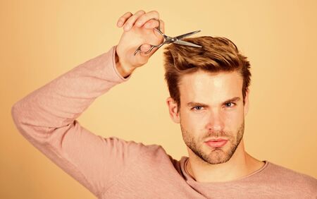 Personal stylist. Bearded man hold scissors. Modern barbershop. Hipster with tool. Designing haircut. Facial care. Cut bangs. Fashion and beauty. Fresh hairstyle. Barbershop concept. Barbershop salonの写真素材
