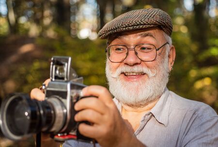 wow i like it. Capture memories from trip. portrait of man holding vintage camera. mature man in...
