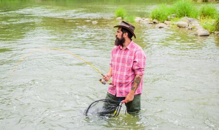 summer weekend. Big game fishing. fisherman with fishing rod. bearded fisher in water. hobby and sport activity. pothunter. mature man fly fishing. man catching fish. Fish Taxiの写真素材