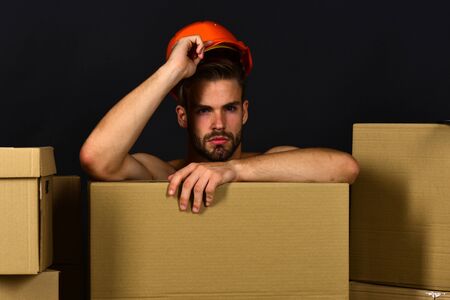 Sexuality and moving concept. Macho with serious face touches helmetの写真素材