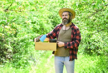 agriculture gardener hobby and garden job. planting seedlings in the garden. People gardening home. Garden tools and flowers on the green garden. man in summer farmland with boxの写真素材