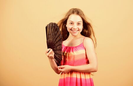 Air conditioner. Waving to create current air. Little girl waving elegant fan. Cooling and ventilation. Summer heat. Fresh air. Kid girl fanning herself with fan. Conditioning system. Climate controlの写真素材