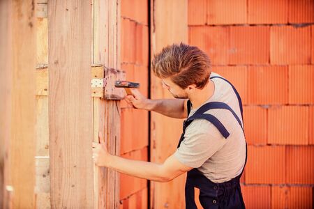 Use hammer. Worker with hammer brick wall background. Building and construction. Engineer with hammer tool. General maintenance and repair workers are hired for maintenance and repair tasksの写真素材