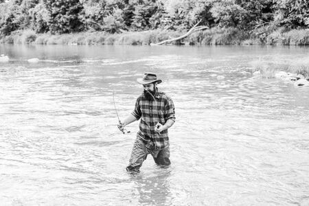 Fisher masculine hobby. Fish on hook. Brutal man stand in river water. Man bearded fisher. Fishing...
