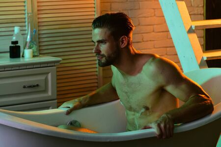 Sex and erotica concept: unshaved macho sitting naked in bathtubの写真素材