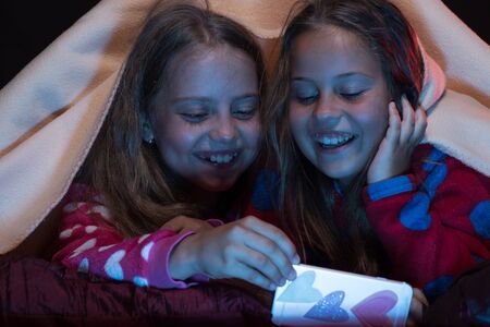 Children and technology concept: little girls having fun.の写真素材