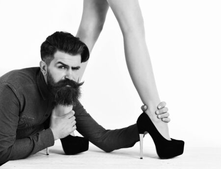 bearded man with sexy female legs has serious faceの写真素材