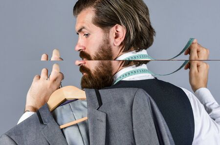i choose this. handsome sartor with tape measure. male beauty and fashion. bearded man tailoring clothes. formal and office wardrobe. businessman. confident tailor designing male jacketの写真素材
