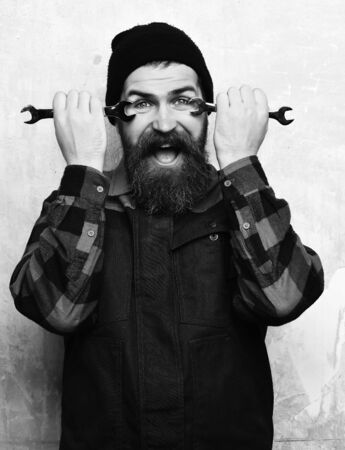 Bearded brutal caucasian mechanic holding metallic wrenchesの写真素材