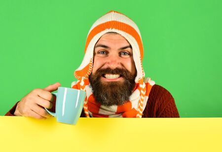 Hipster with cheerful face has warm tea or coffee cupの写真素材