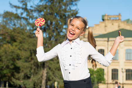 Toothsome dessert. Happy dessert girl hold lollipops. Little child enjoy dessert summer outdoors. Dessert recipe. Food and snack. Candy shop. Sugar confectionery. Summer holidaysの写真素材