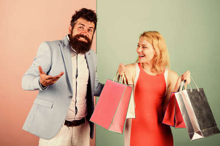 Shopaholic girlfriend. Black friday concept. Woman on shopping tour. Family budget. Man girl with paper bags. Addicted shopaholic. Shopaholic problem. Consumerism addictive behavior. Couple in mallの写真素材