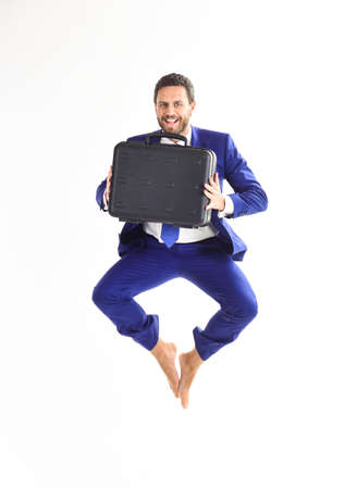 Excited business man with briefcase jumping in mid-airの写真素材