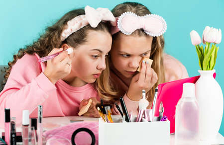 skin care cosmetics for children. beauty and fashion. two happy girls at hairdresser. friendship and sisterhood. family bonding time. childhood happiness. retro kids put on makeup. Confident beautyの写真素材