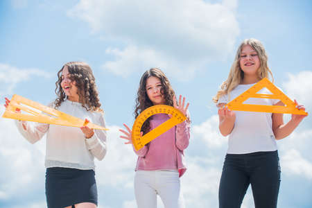 Education. Geometry favorite subject. Education and school concept. School students learning geometry. math. exact sciences. three girls with protractor and triangle ruler. back to schoolの写真素材