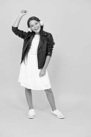 Audio concept. Kid enjoy modern music. Music device. Rock for my soul. Party wherever you are. Cherishing inner rocker. Listening music. Girl with headphones. Hobby concept. Happy child in earphonesの写真素材