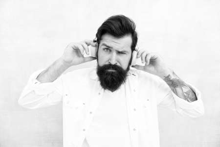 listening to music outdoor. favorite songs and tracks. Rhythm for walk. Hipster wearing adjustable white headset. bearded man music lover. Headphones with wireless technology. Inspiring music conceptの写真素材