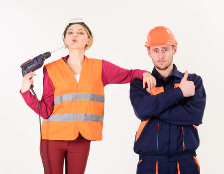 Woman with confident face in helmet, hard hat holds drillの写真素材