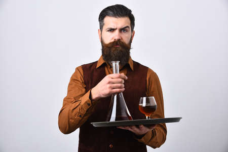 Barman in vintage suede leather waistcoat serves scotch or brandy.の写真素材