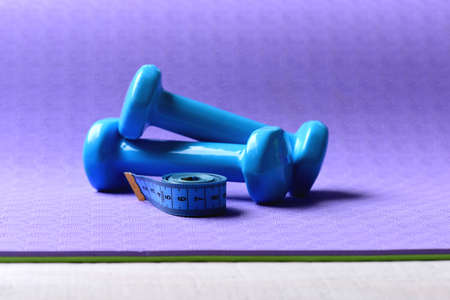 Barbells next to roll of tape. Dumbbells and measure tapeの写真素材