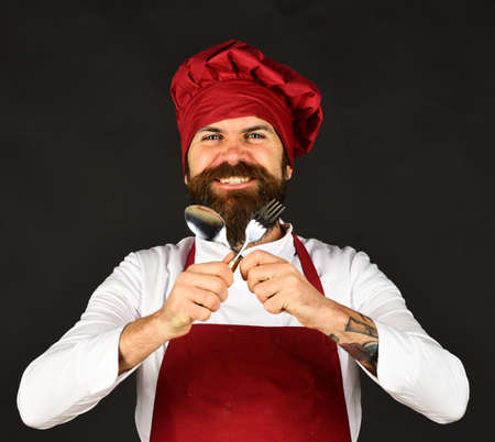 Man with beard holds kitchenware on black background.の写真素材