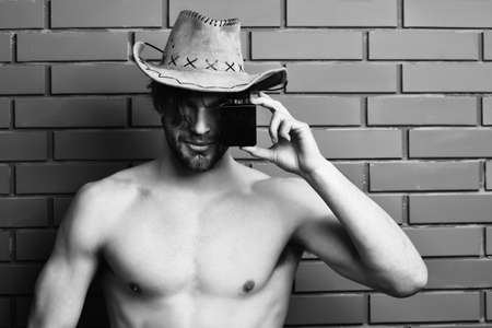 Caucasian bearded sexy macho man in cowboy hat holding perfumeの写真素材