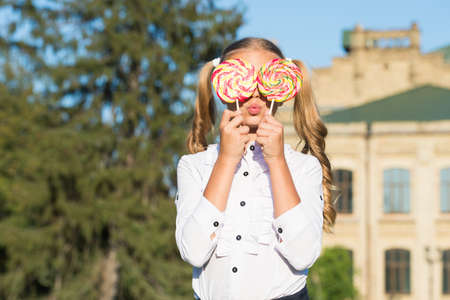 Sweet look. Sweet tooth sunny outdoors. Little child hold candies. Sweet treats. Dessert and food....