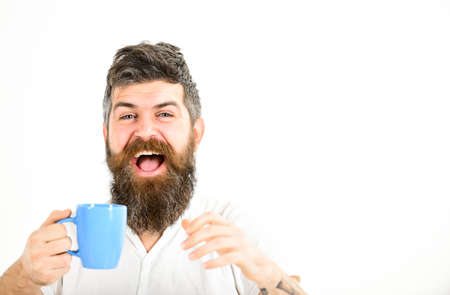 Hipster with beard holds mug. Man with happy faceの写真素材
