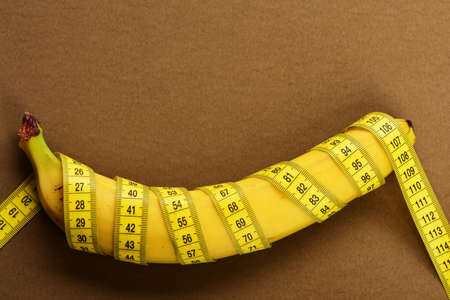 Rolled centimeter ruler spinned around fresh fruit.の写真素材