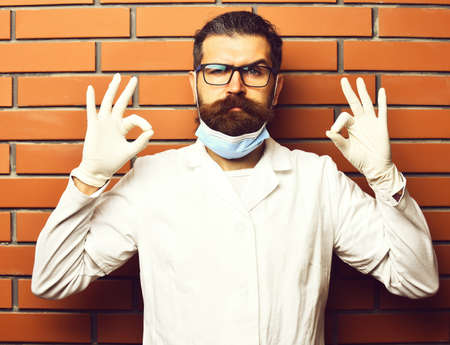 Bearded brutal caucasian doctor or postgraduate student in glovesの写真素材