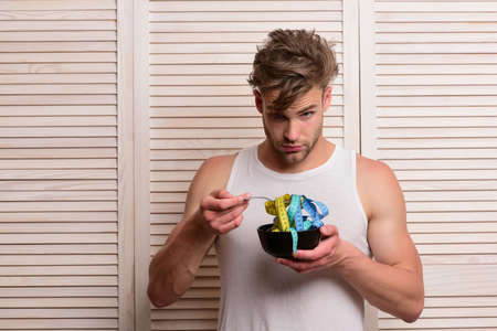 Diet and health concept. Guy eating measuring tapeの写真素材
