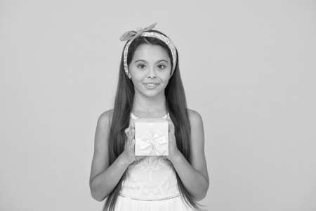 Delivery service. Perfect gift concept. Celebrate spring holidays. Cute small kid adorable dress. Girl long hair hold gift box. Present for teen girl. Birthday party. Buy gift. Online shoppingの写真素材