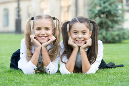 Find happiness in simple things. Happy children relax on green grass. Enjoying happiness. Small...