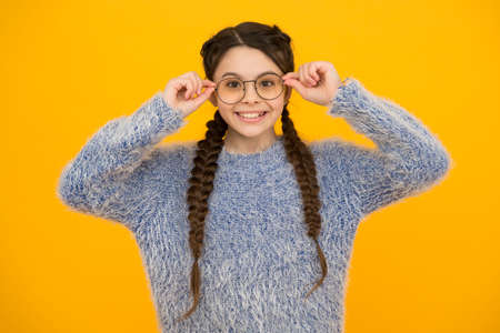 focus on what matters. cheerful teen has bad sight. Hair braided in braids. little beauty in glasses. happy childhood. small girl has nice smile. kid hairstyle fashion. smiling child with long hairdoの写真素材