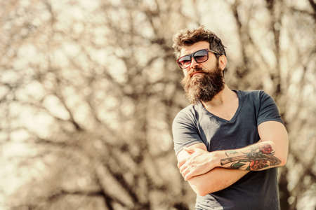 Bearded man wear modern fashionable sunglasses. UV filter. Man bearded with sunglasses nature background. Bearded hipster brutal man wear protective sunglasses. Hipster confident in dark sunglassesの写真素材