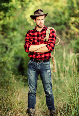 Cowboys are gentlemen. wild west rodeo. man in hat outdoor. man checkered shirt on ranch. Vintage style man. Wild West retro cowboy. cowboy with lasso rope. Western. western cowboy portraitの写真素材