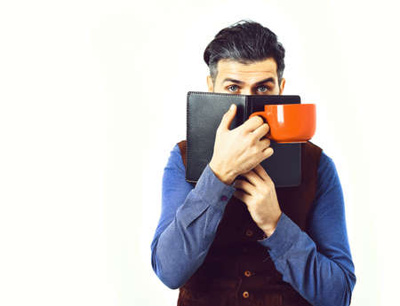 bearded man holding notepad, cup of tea with serious face