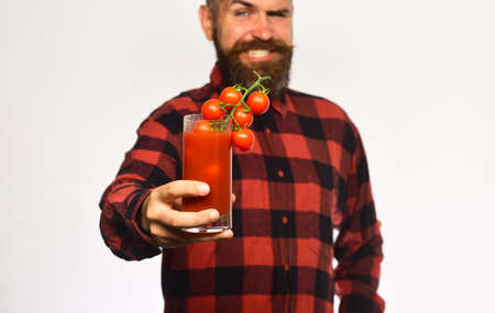 Guy with his harvest. Man with beard holds tomato juice