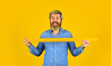 mature bearded man hold measuring ruler.の写真素材