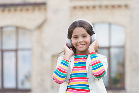 happy schoolgirl in stylish hipster outfit. childhood happiness. kid in digital earphones. small...