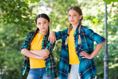 Nice pupils. Casual hipsters outfit. portrait of happy sisters. little kids girls in shirt. Two...