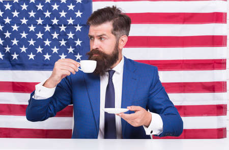 a rightful country. bearded man drink coffee cup. American education reform in july 4. American citizen at USA flag. drinking coffee on tribune. american politician in election. his election campaignの写真素材