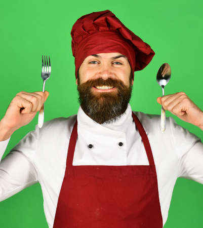 Man with beard holds kitchenware on green background
