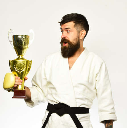 Combat master celebrates victory in competition. Man with beard in kimono on white backgroundの写真素材